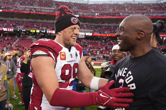 J.J. Watt and DeMeco Ryans embrace on the field after a game during the 2022 season.